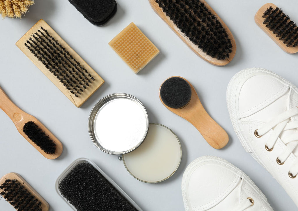 Extend the life of your shoes with some practical shoe care tips. Image of non brand shoe care tools, brushes and creams and white sneakers.